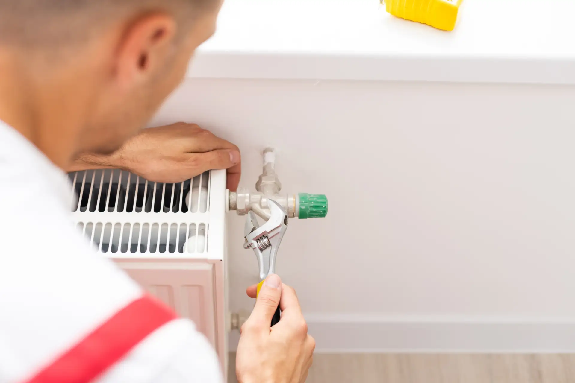 Working on a radiator valve with a spanner