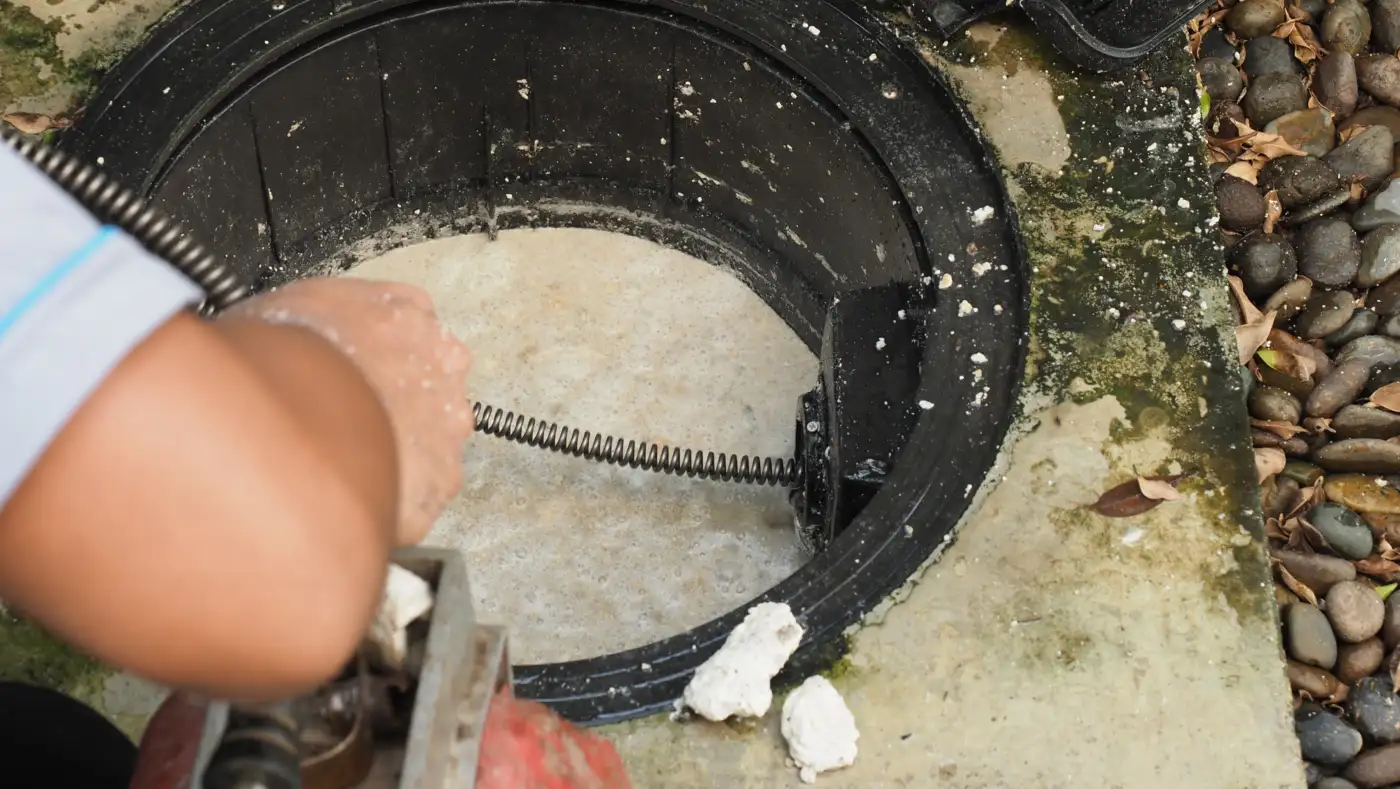 Clearing a drain with a drain auger