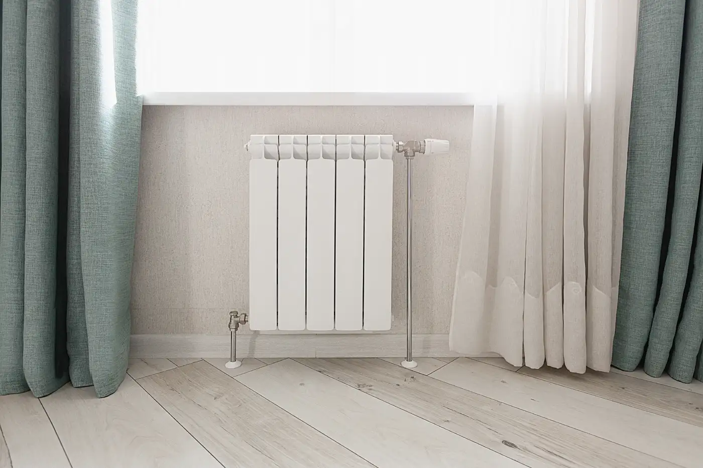 A white radiator under a window in a home