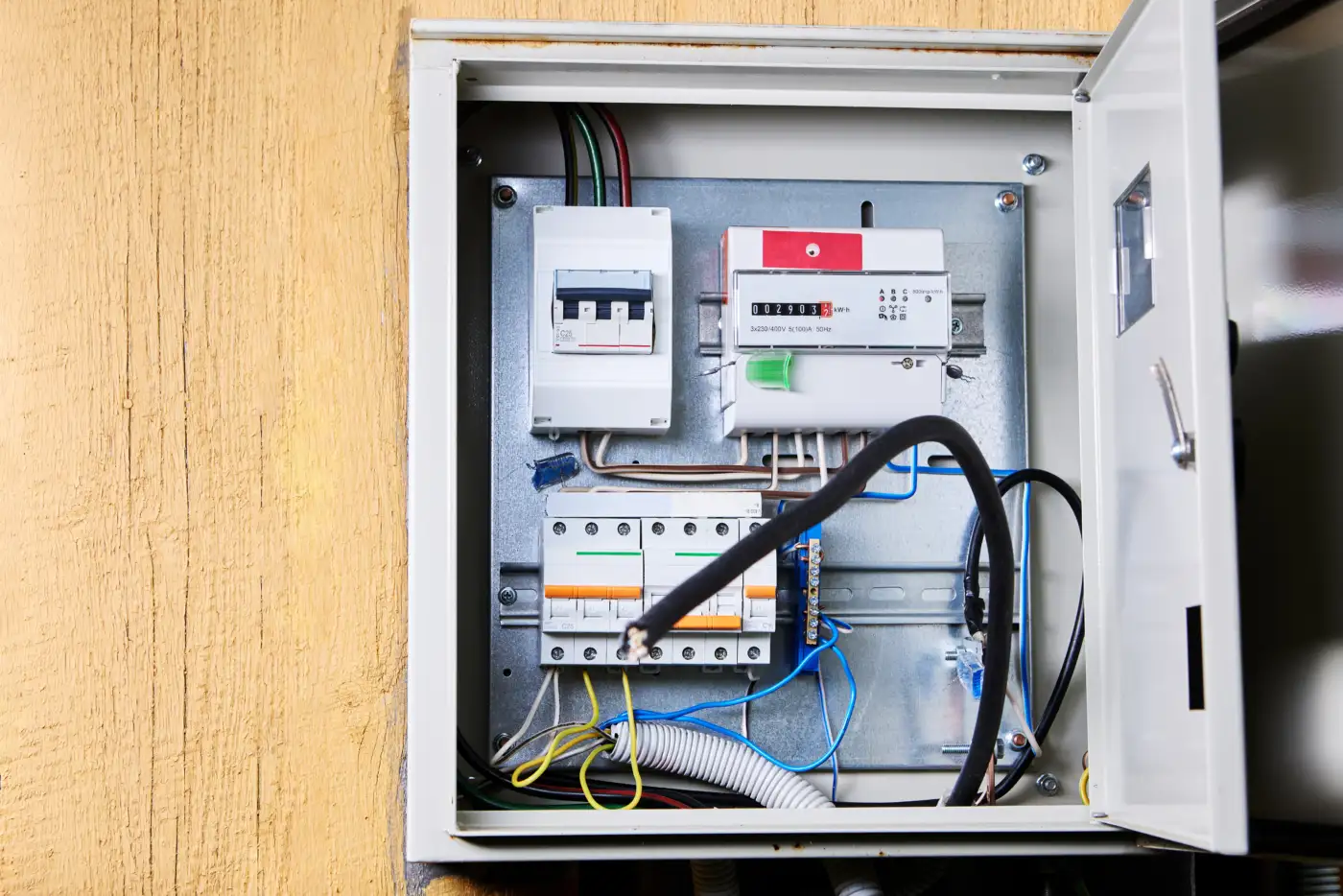 An open consumer unit showing circuit breakers and wiring