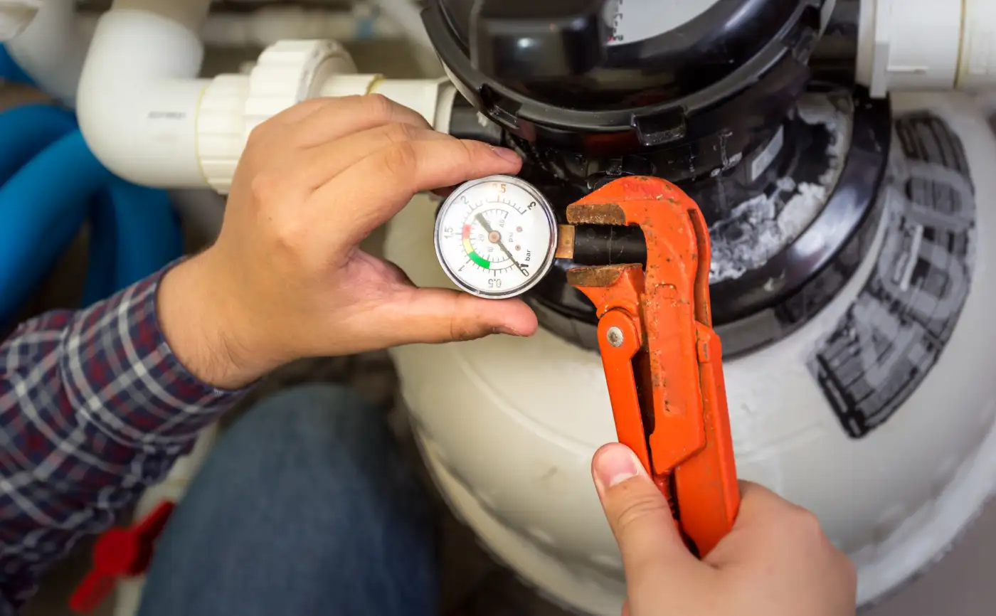 A plumber checking a pressure gauge during a boiler service