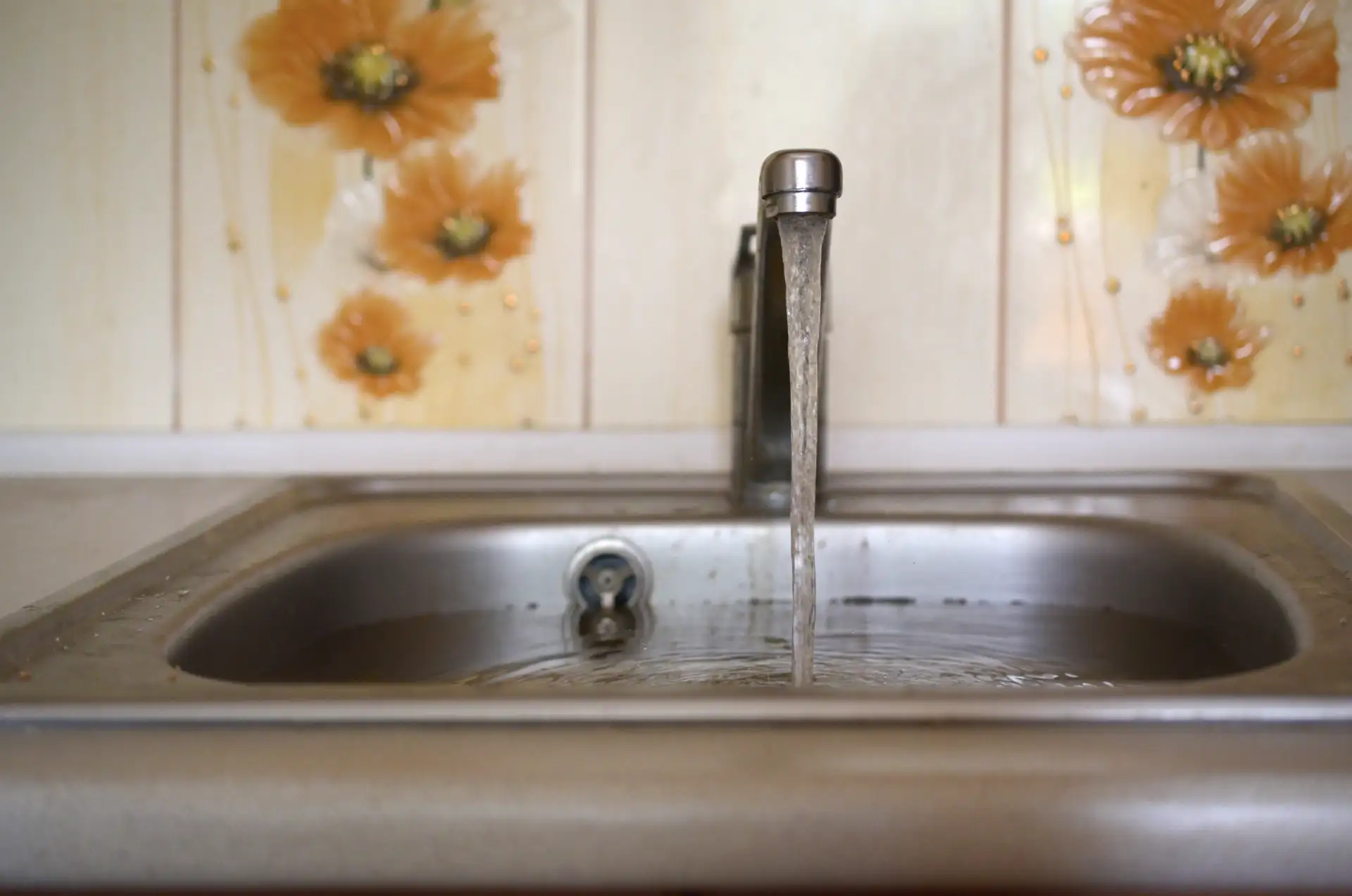 A kitchen sink full of water that won't drain