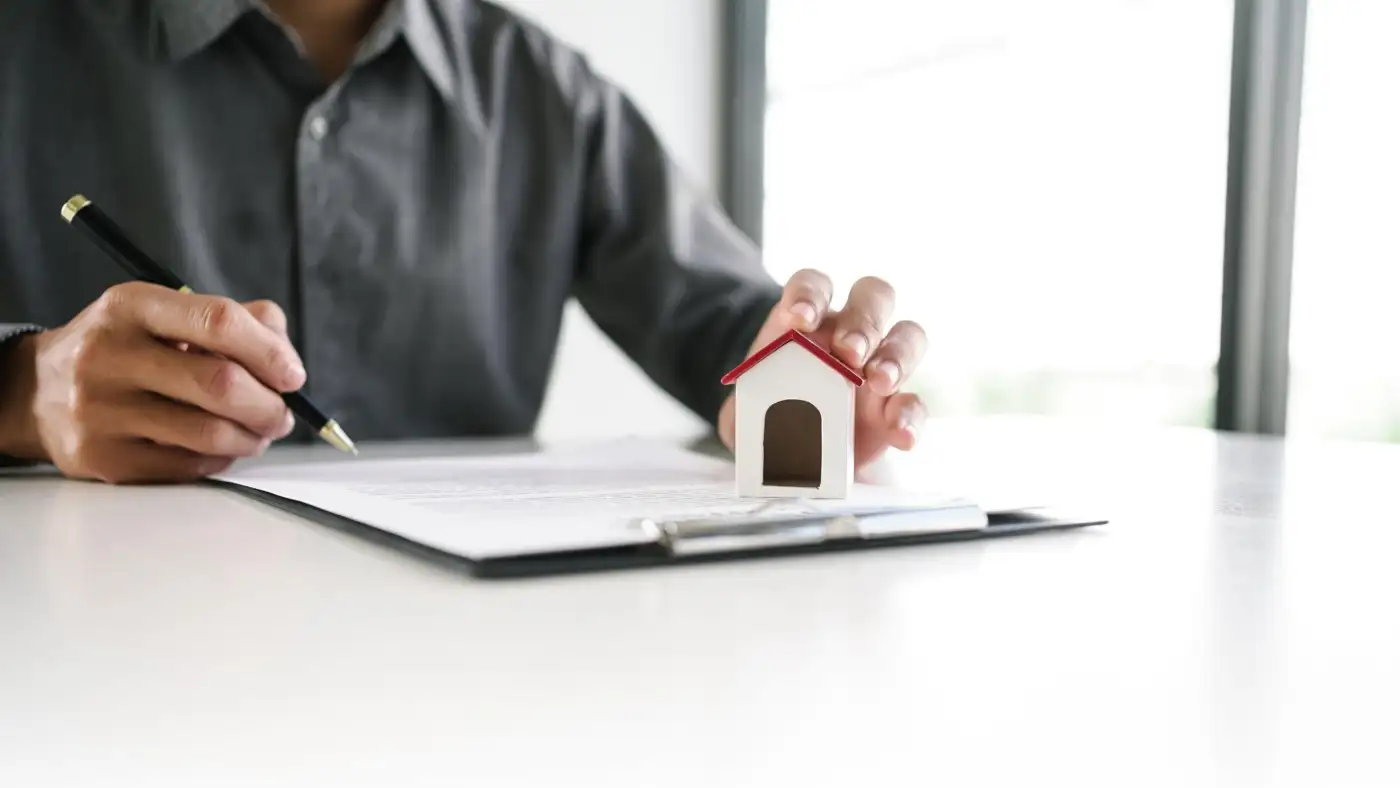 A landlord completing the Isle of Man private landlord registration form at a kitchen table