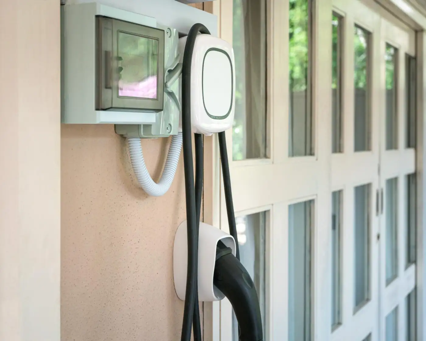 A wall-mounted home EV charger on a driveway