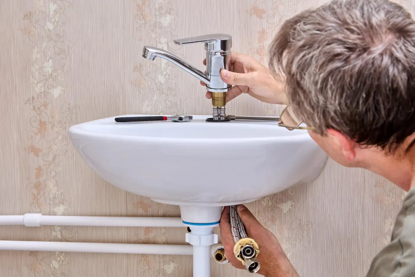 A mid-range bathroom suite being fitted against existing pipework