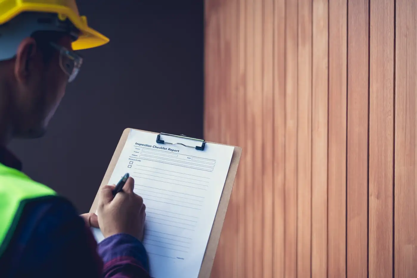 An engineer with a clipboard recording an inspection of a domestic boiler
