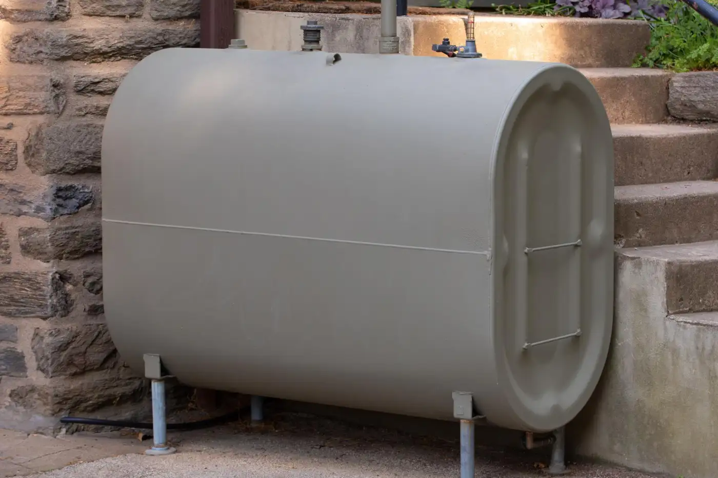 An external domestic heating oil tank beside a rendered island house