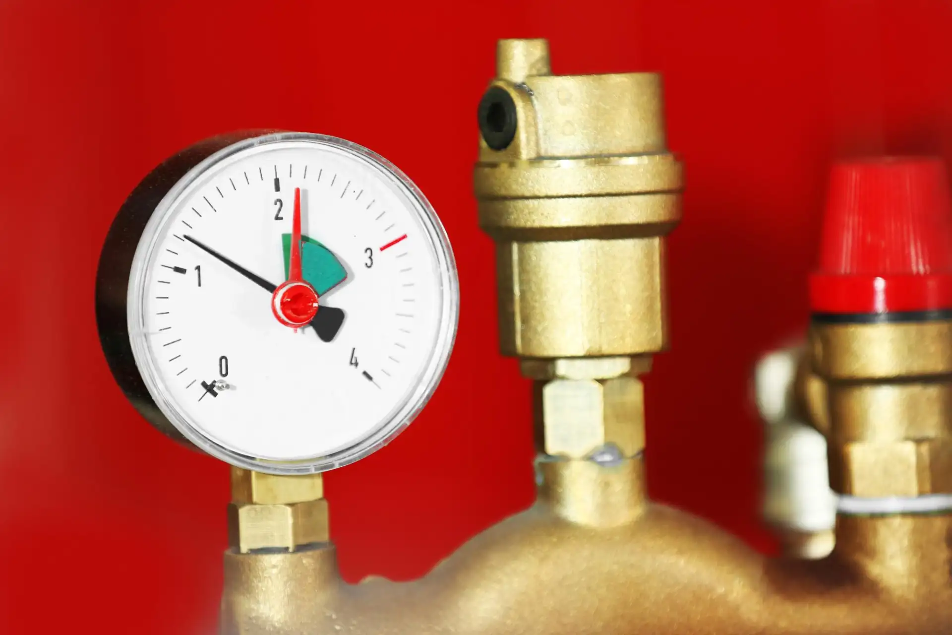 A homeowner checking the pressure gauge on a wall-mounted combi boiler