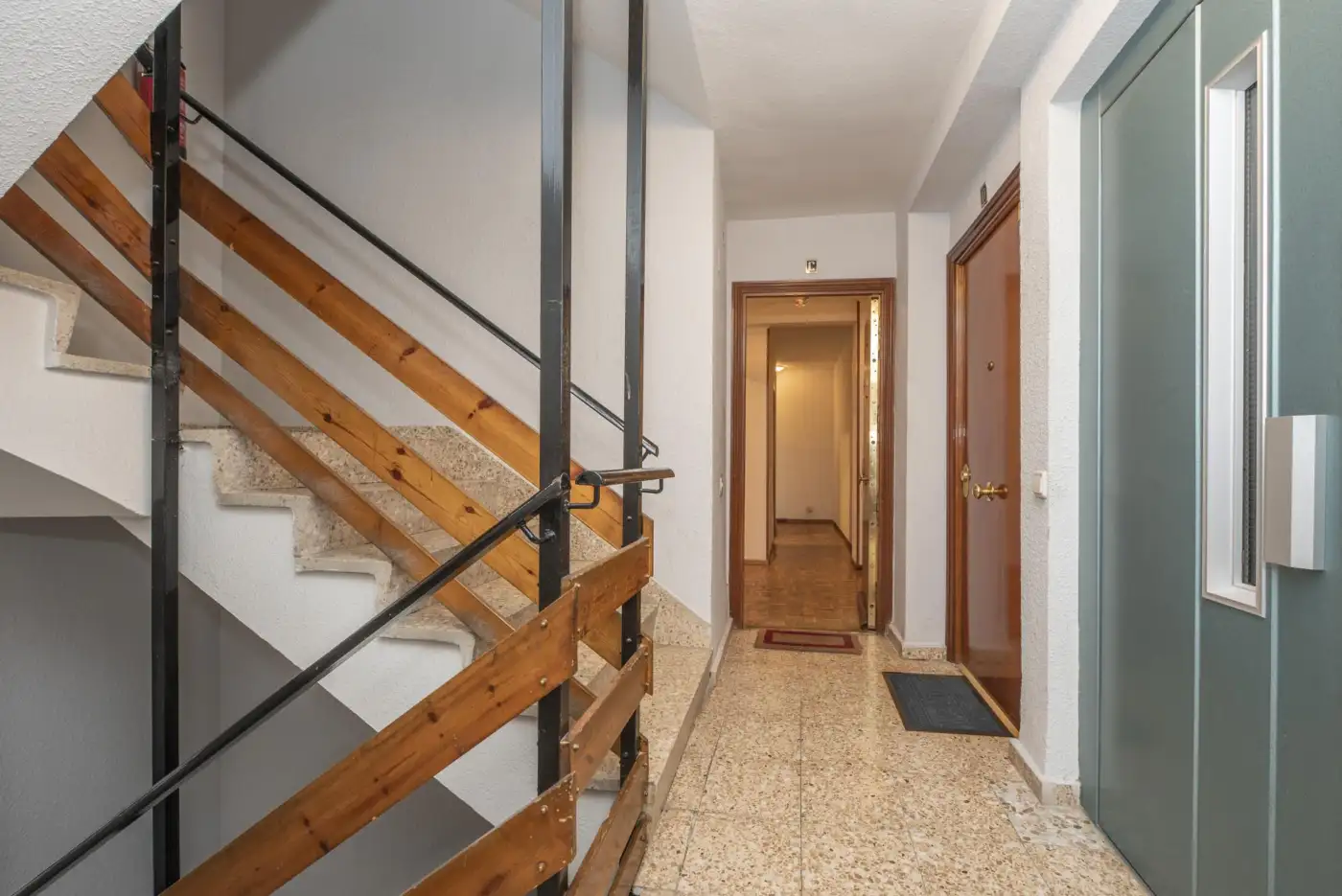 A tidy shared-house stairwell kept clear as a fire-escape route