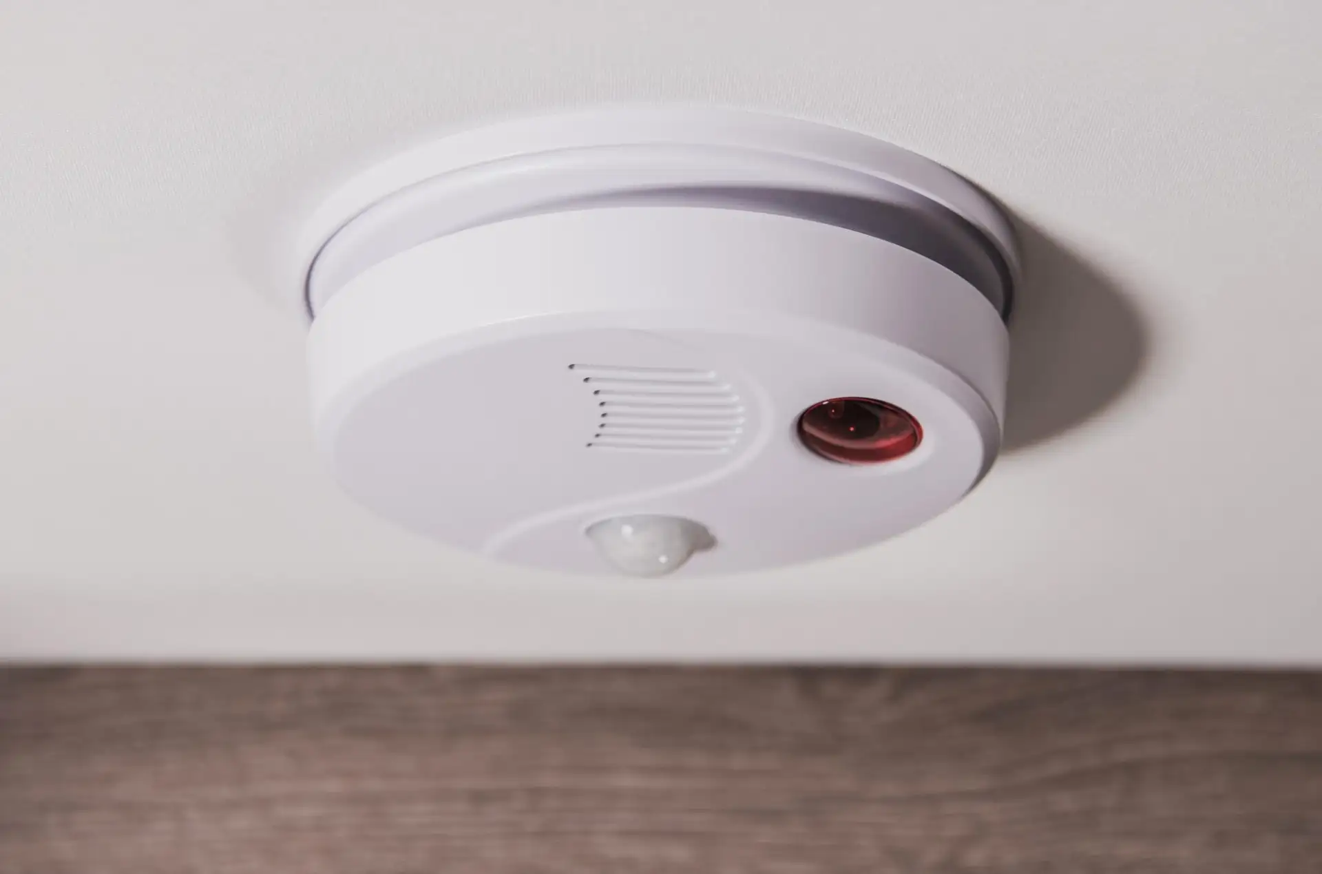 A carbon monoxide alarm mounted on the wall near a domestic boiler in an Isle of Man home