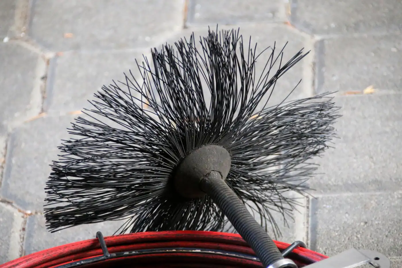 A close-up of a chimney sweeping brush and rod