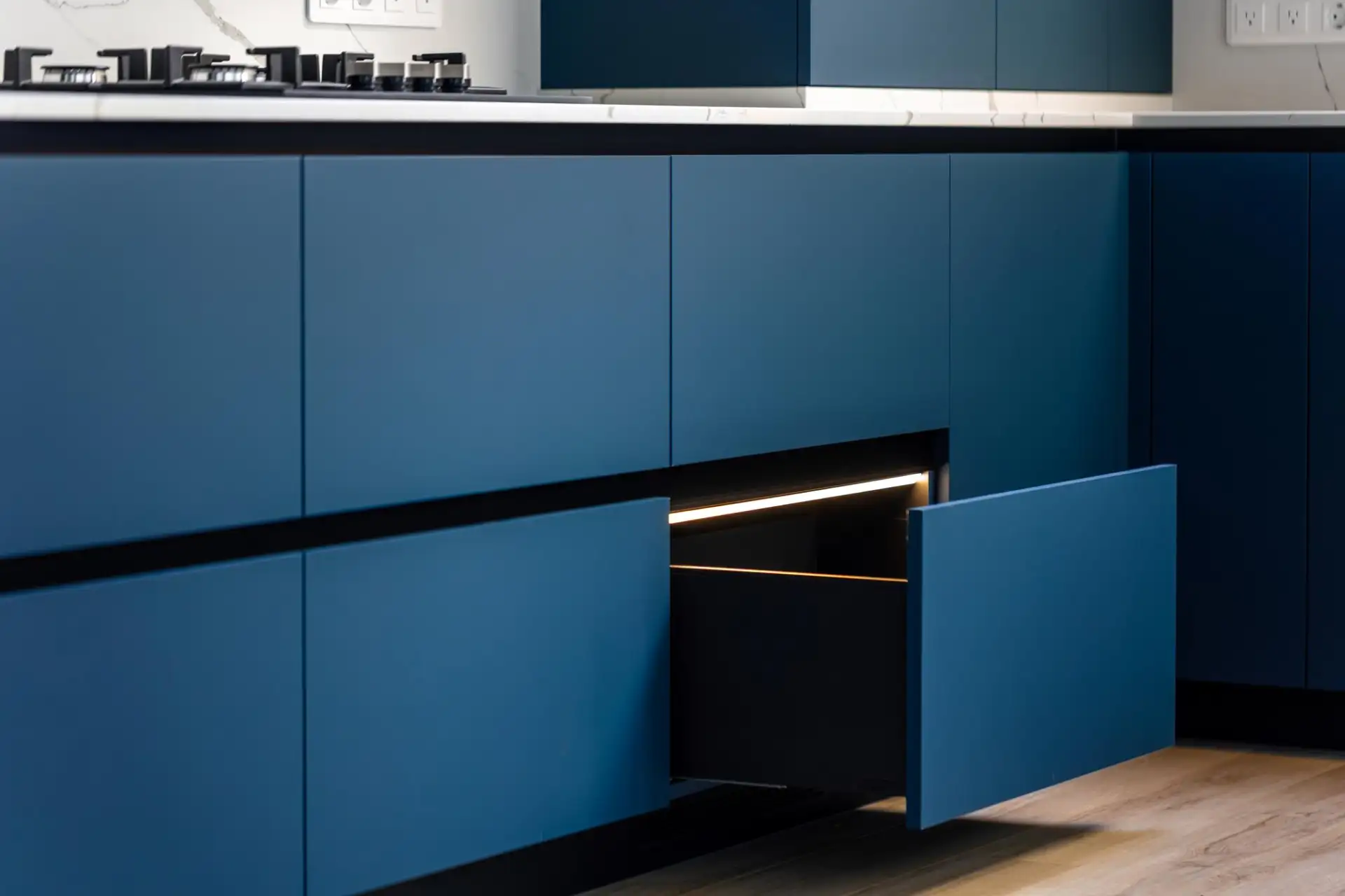 A finished modern fitted kitchen with an island, timber cabinetry and stone worktops