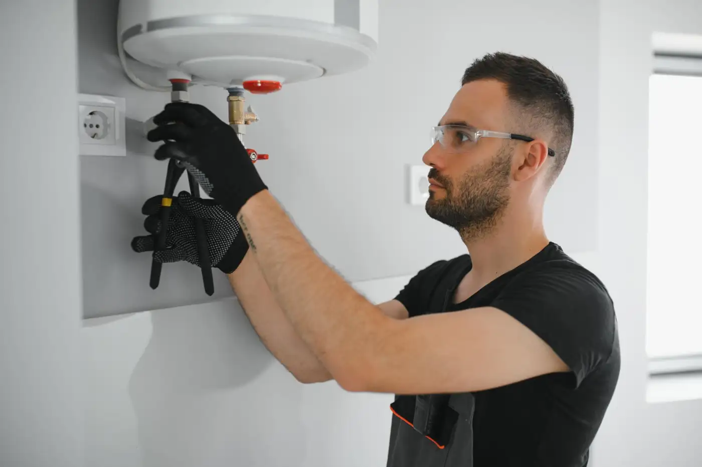 A heating engineer checking a wall-mounted boiler