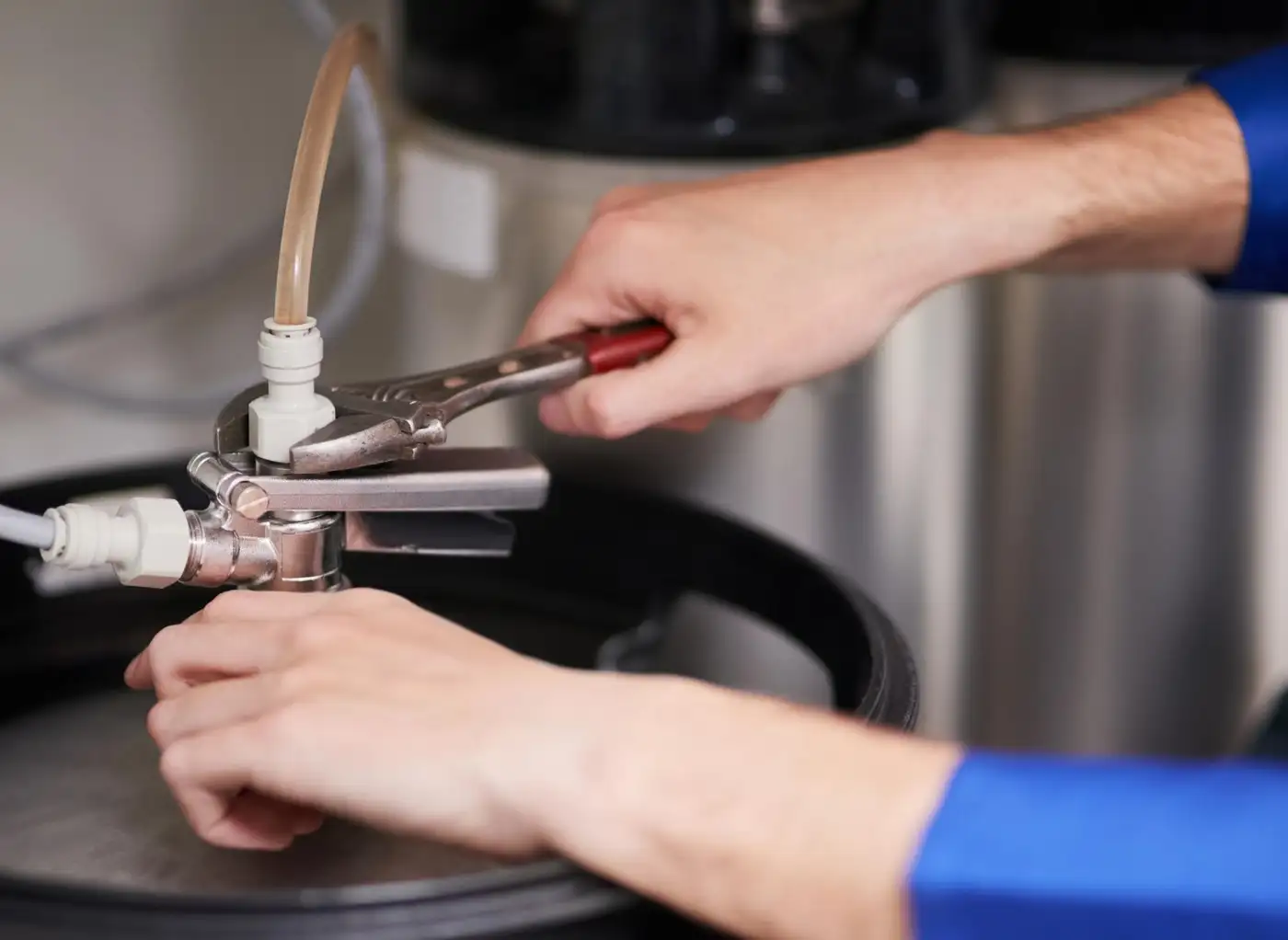 Hands working on a domestic hot water heating system
