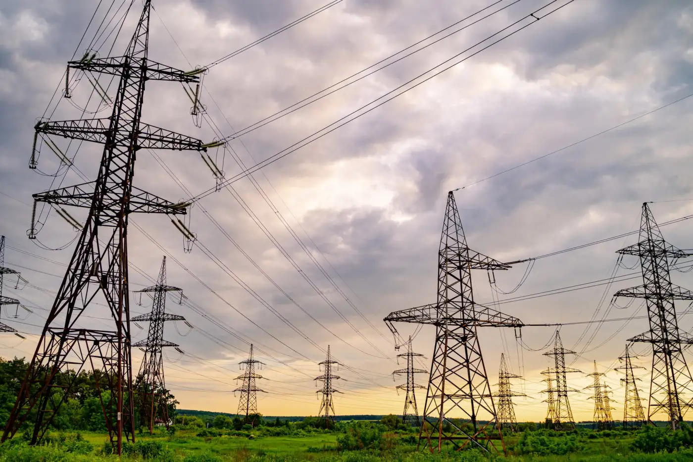 High-voltage electrical pylons and power lines across a green field