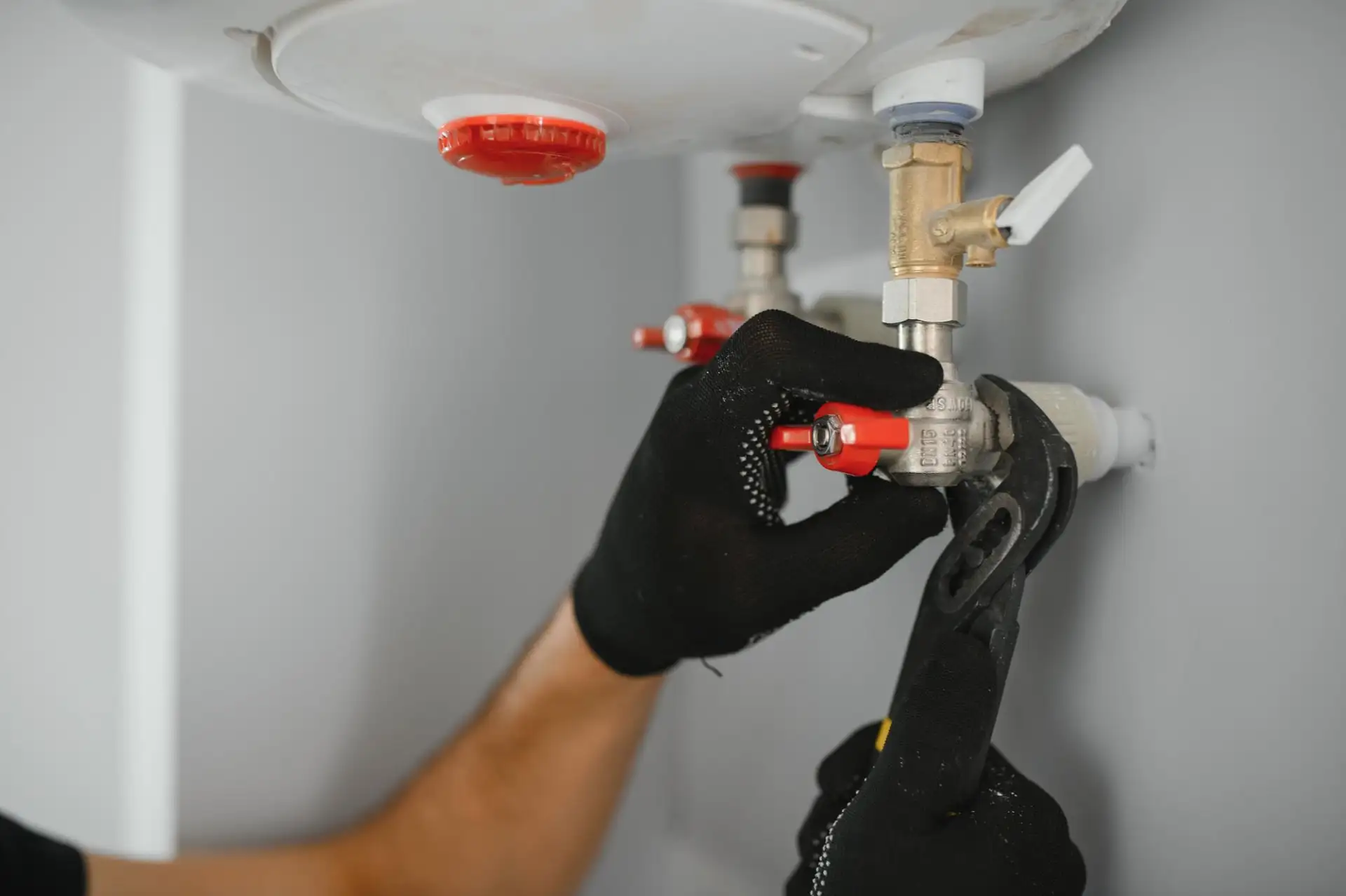 A gloved hand working on a domestic boiler